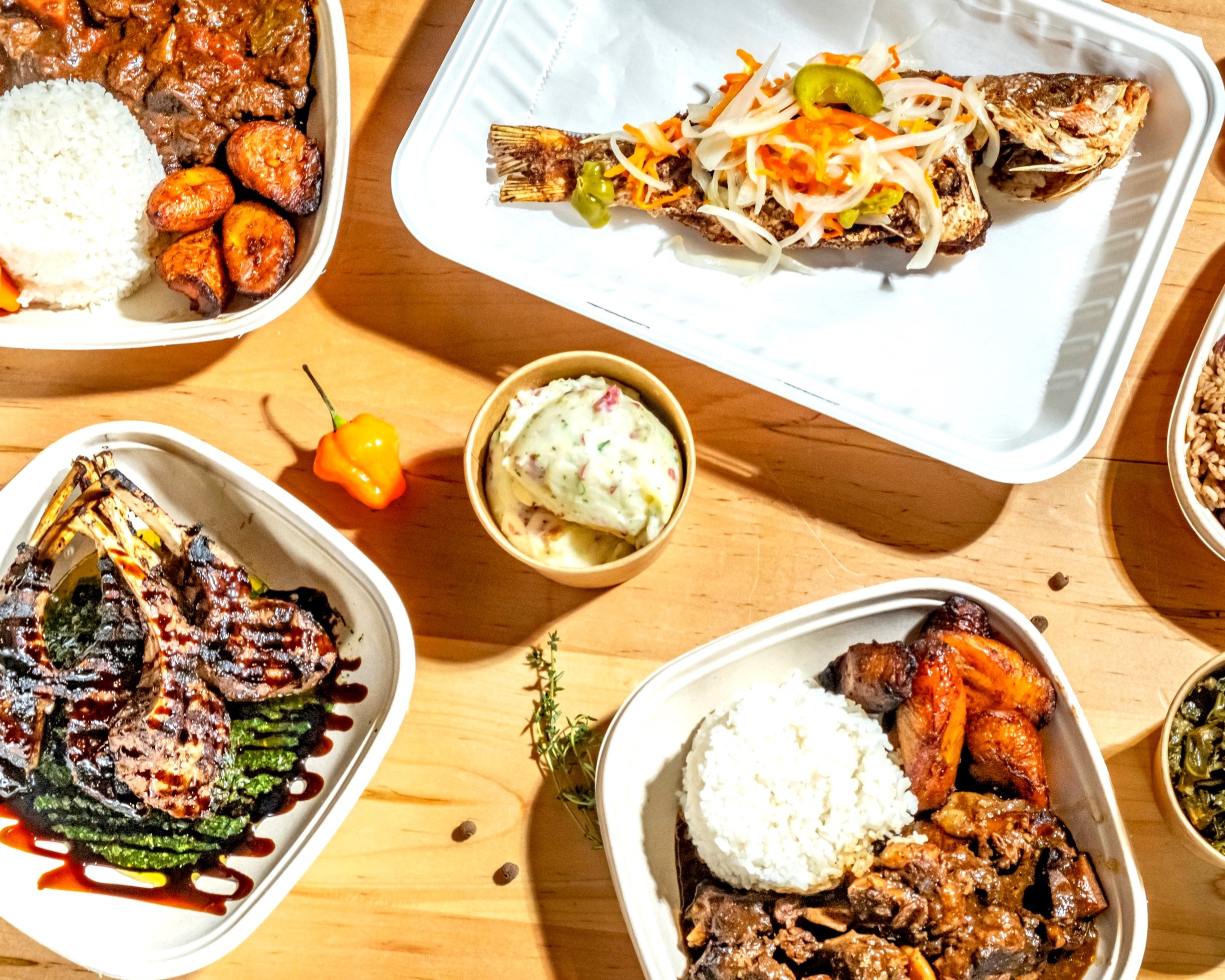 Caribbean food spread featuring jerk chicken, rice and peas, and plantains